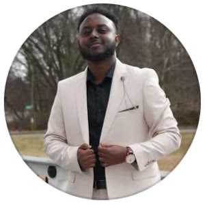 Adonay in a cream blazer, smiling outdoors
