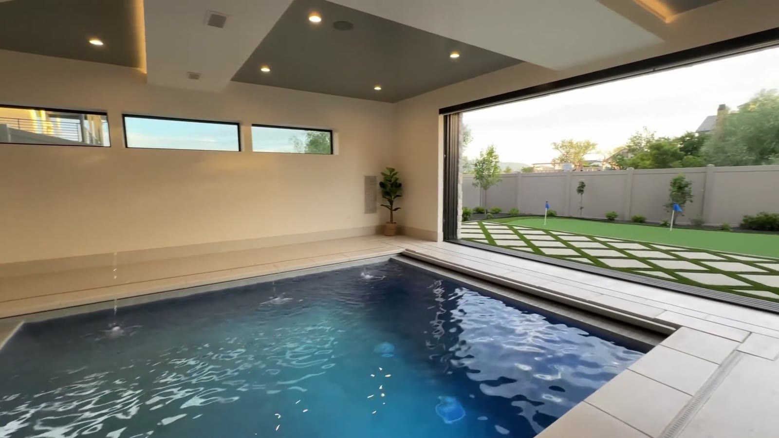 Indoor pool with a wall open to the back yard