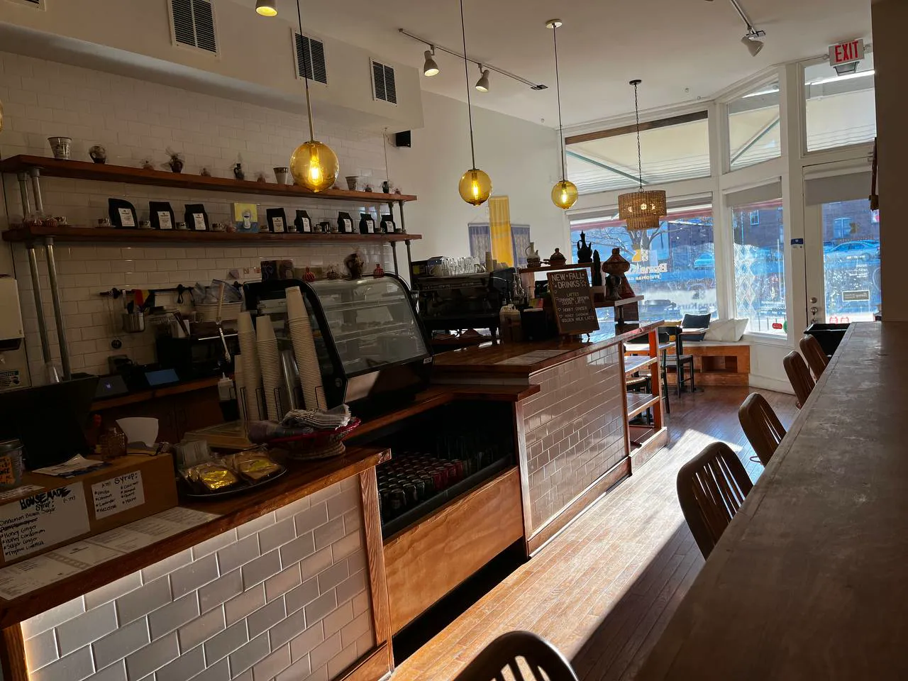 The coffee bar with white subway tile, wooden shelves and amber glass pendant lights