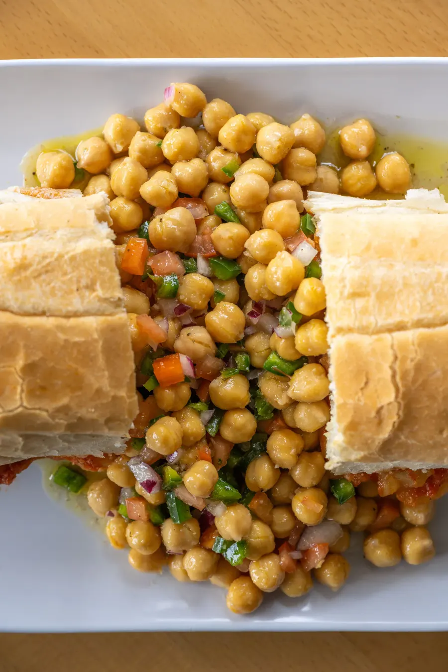 Ertib, the Ethiopian potato sandwich, cut open beside a chickpea salad