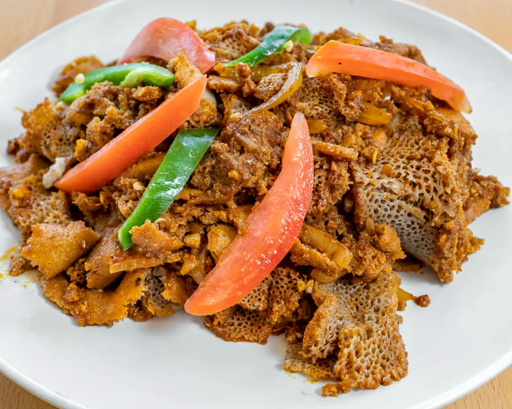 Injera fir fir topped with tomato and green pepper