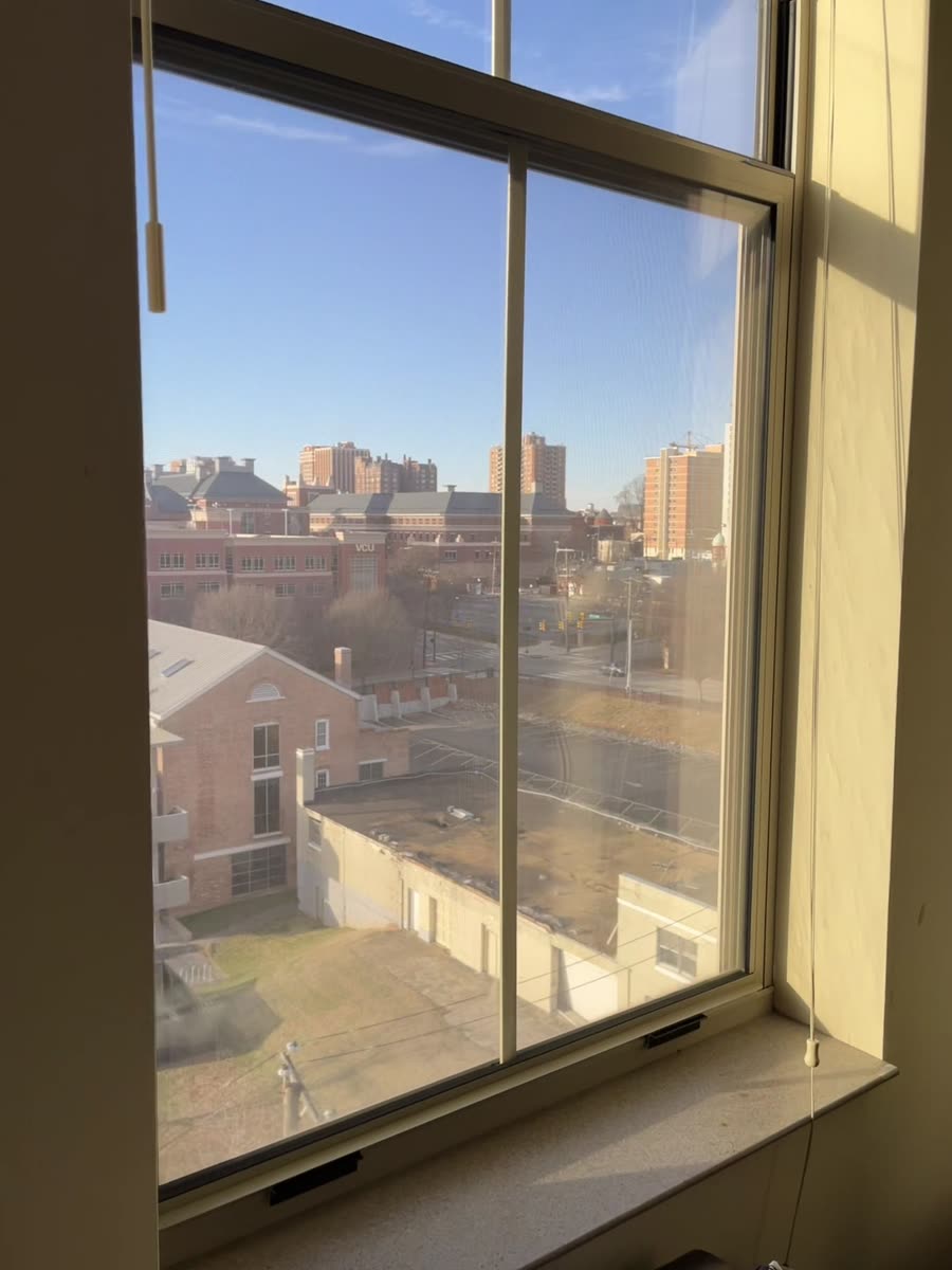 Sunny city skyline seen through tall corner windows