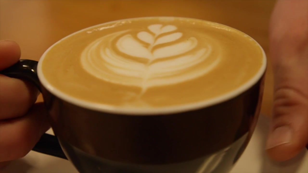 Latte with a rosetta in a black mug