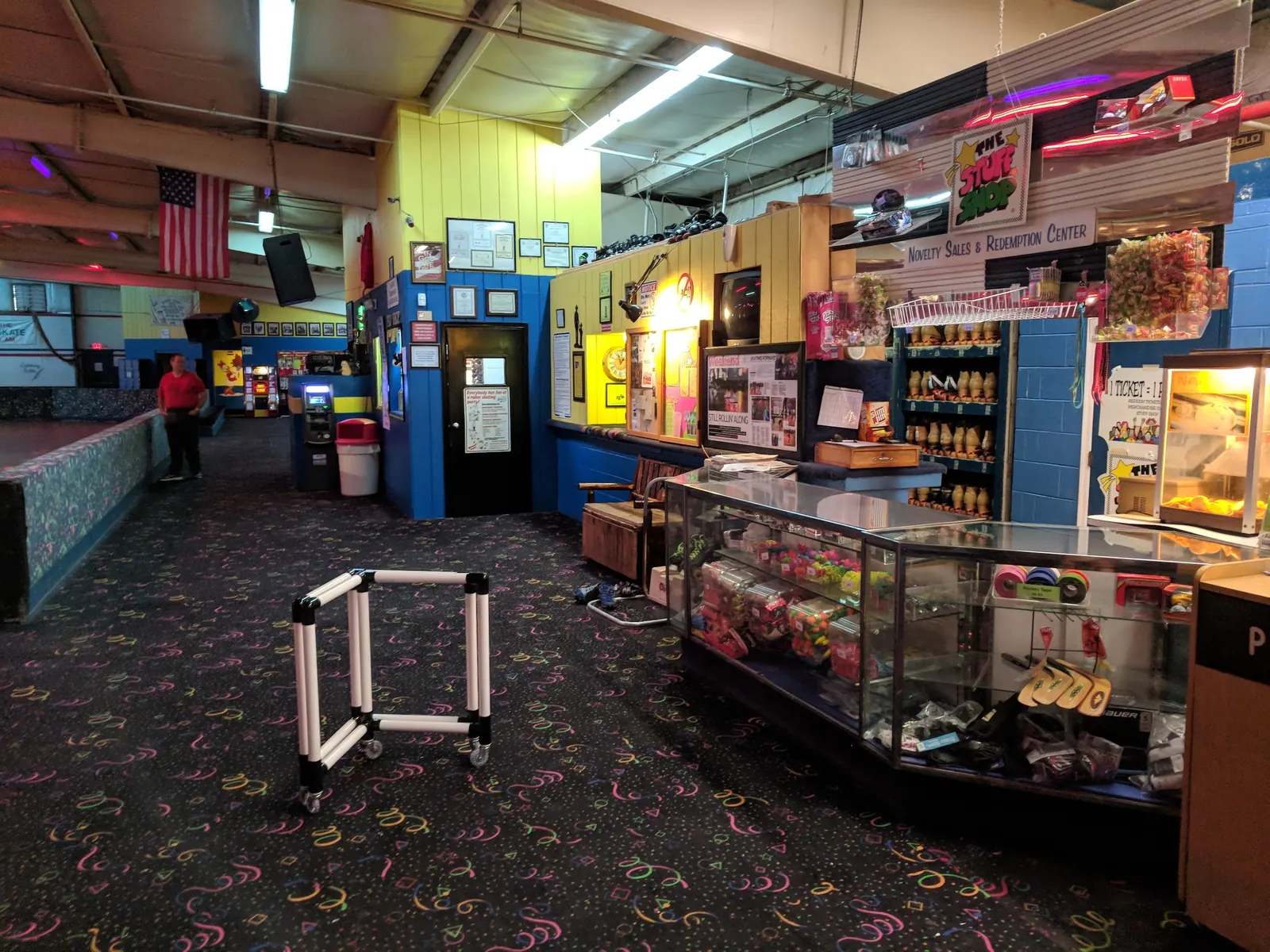Snack counter with a popcorn machine and glass candy case beside the lobby carpet.