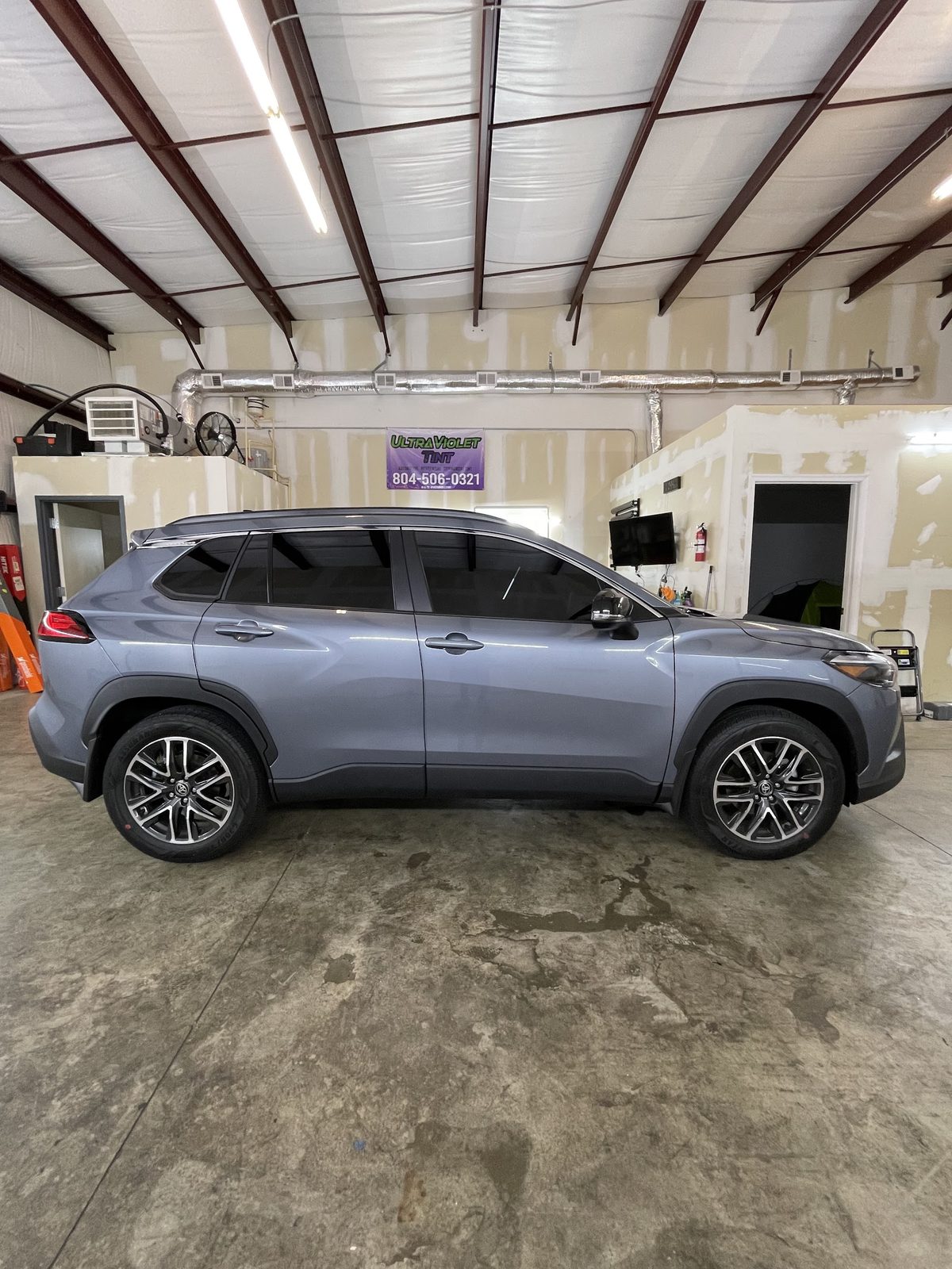 Grey Toyota Corolla Cross with tint inside the shop